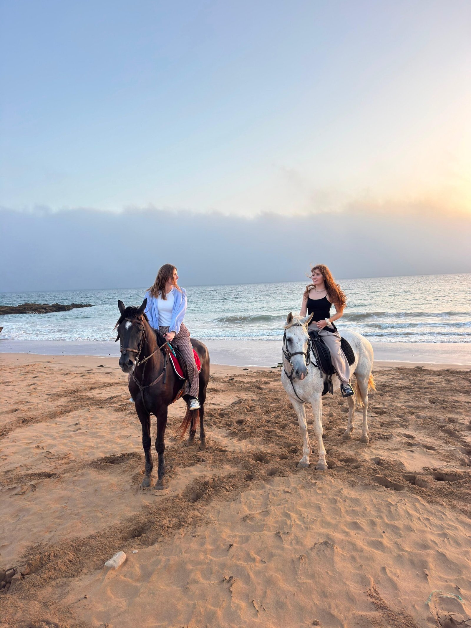 Horse riding near Tamraght — two riders on the beach in soft morning light
